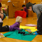 twee kinderen op kleurrijke matten besprelen een xylofoon